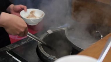 Vietnam Phobo Çorbası. Açık büfedeki büyük kaplardan sıcak çorba servis eden eller. Taze ve ev yapımı mutfağı ön plana çıkarıyor. Yüksek kalite 4k görüntü