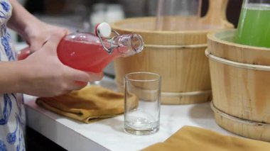 Cam fincanlar ve pipetlerle servis edilen ferahlatıcı karpuz suyunun detaylı bir görüntüsü. Büfedeki şişelerde karpuz suyu