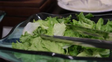 Tabaklar dolusu taze brokoli salatası karışık sebzeler ve sosla servis malzemeleriyle bir şarküteri bölümünde sergileniyor..