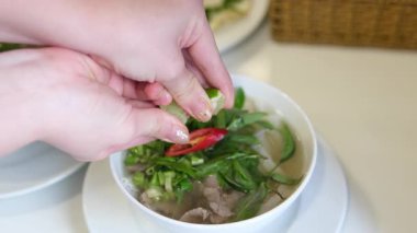 Limonlu çorbaya sıkışan el, Bangkok 'un hareketli restoranlarında bir kase Po' nun üzerine limon sıkıyor ve bulaşık tadını arttırıyor. Yüksek kalite 4k görüntü