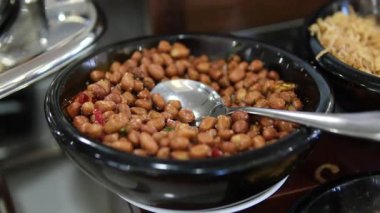 Tahta bir kasede yer fıstığı, siyah bir tahtada kabuksuz fıstık.