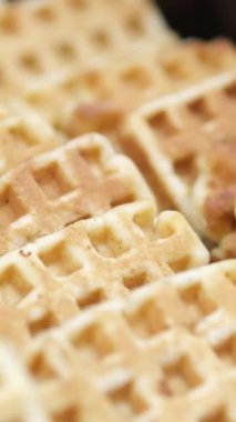 Bol sıvı çikolatalı bir tabakta Belçika waffle 'ı dökülüyor. Yakın çekim, doli çekim nefis dokuları ve tatlı kahvaltı anını yakalıyor..