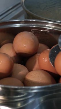 Bir düzine yumurta kaynayan bir tencerede zarif bir şekilde kaynatılır. Kabaran su her yumurtayı nazikçe sarıp mükemmel pişmiş mücevherlere dönüştürür. Yumurtalarının sarısı açılmayı bekler. Yüksek kalite 4k görüntü