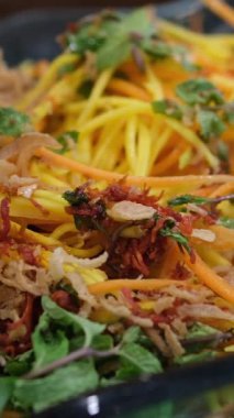 Sarı rende mangoyu ince şeritlere ayırır ve beyaz kasede biriktirir. Canlı sarı mango parçaları jülyen renginde. Basit yemek hazırlığı..