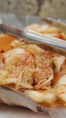 Ev yapımı kimchi, bir Kore mirası tabağı, küçük bir kasede servis maşasıyla servis ediliyor..