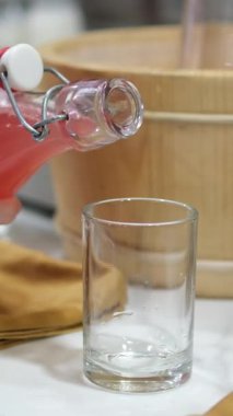 Cam fincanlar ve pipetlerle servis edilen ferahlatıcı karpuz suyunun detaylı bir görüntüsü. Büfedeki şişelerde karpuz suyu