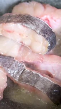 Kızartma tavasında kızarmış balık bifteği. Restoranda kızgın yağda balık pişirmek. Yüksek kalite 4k görüntü