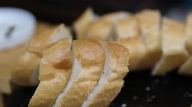 Özel bıçakla taze buğday ekmeği keserken yakın çekim. Kahvaltı ya da öğle yemeği için hazırlık. Yemek ve içecek konsepti 4K görüntüler. Yüksek kalite 4k görüntü