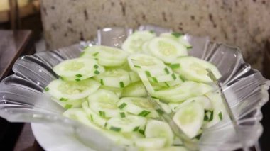 Salatalık dilimleri, koyu siyah arka planda güçlü bir yansımayla ortalanmış. Yüksek kalite 4k görüntü