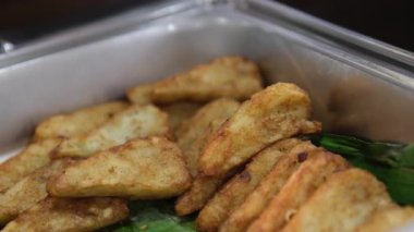 Kızarmış tofu parçaları tabakta taze yeşil biberlerle süslenmiş çıtır çıtır altın-kahverengi tofu küplerini gösteriyor. Tofu iştah açıcı görünüyor, onu ideal bir vejetaryen aperatifi ya da meze yapıyor.