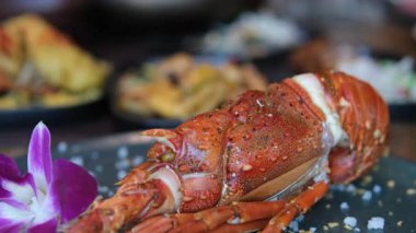 Izgara Maine ıstakoz kuyruğu kızarmış brokoli ve siyah bir taş tabakta orzo ile süslenmiş, yüksek kalite 4K görüntü.