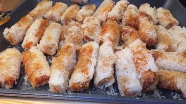 Yumurta ruloları kızgın yağ tenceresinde kızartılıyor ve metal bir kaşık ileri geri hareket ediyor. Yüksek kalite 4k görüntü