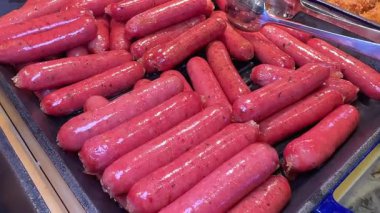Açık büfede bir sürü açık pembe sosis var. Pişmemiş kırmızı sosisler. Yüksek kalite 4k görüntü