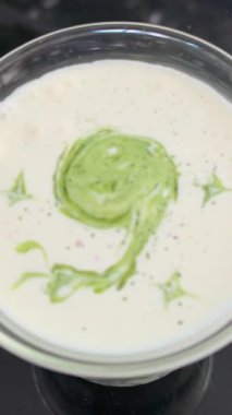 Yoğunlaştırılmış kibrit yeşil çay kafede küçük bir parça suyla taze süte dökülüyor. Yüksek kalite 4k görüntü