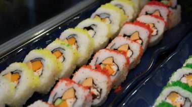 Suşi meraklıları için mükemmel rengarenk ve lezzetli bir seçim sunan çeşitli maki suşi sarmaları. Yüksek kalite 