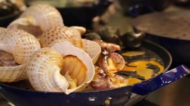 Paella karışımı, kızarmış deniz ürünleri mavi yengeç, midye, büyük karides, kalamar mürekkep balığı ve baharatlı biber soslu ızgara balık sarımsağı ve limon. 