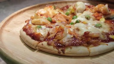 Yakın çekim. İtalyan mutfağı. Kirazlı, domatesli ve peynirli nefis pişmiş pizza. Pizza Kesicisiyle Dilimlenmiş Lezzetli Yemek Pişirme Ekipmanı. Lezzetli Pizza Pişirme 