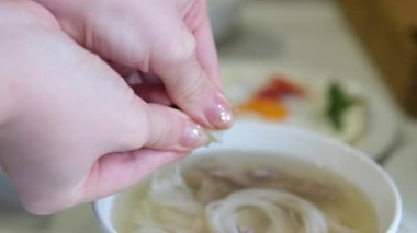 Vietnamlı Po Çorbacısı sokakta pirinç vermicelli çorbası hazırlıyor. Vietnam sokaklarında sahte çorba pişiriyor. Sağlıksız koşullar. nüfus.
