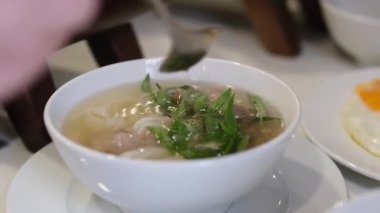 Vietnamlı Po Çorbacısı sokakta pirinç vermicelli çorbası hazırlıyor. Vietnam sokaklarında sahte çorba pişiriyor. Sağlıksız koşullar. nüfus.