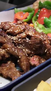 Izgara et sebzesi. Tepsilerde kızarmış et ve susamlı Asya mutfağı sebzeleri brokoli domates havuçları güzel sunum iyi yemek seçimi