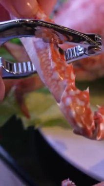 Şef kaynamış büyük yengeci hazırlıyor. Pençeleri çatlatması için mutfak çekiçiyle tahta kesme tahtasına, deniz ürünlerine vuruyor. Yüksek kalite 4k görüntü