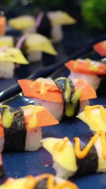 Suşi meraklıları için mükemmel rengarenk ve lezzetli bir seçim sunan çeşitli maki suşi sarmaları. Yüksek kalite 