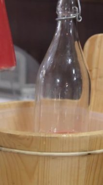 Süpermarket raf ortamında gerçekleşen bir şişe seçiminde karpuz suyu, müşteri eli birden fazla içecek seçeneği arasında parlak cam kaplara doğru uzanıyor. Yüksek kalite 4k 