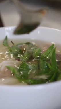 Vietnamlı Po Çorbacısı sokakta pirinç vermicelli çorbası hazırlıyor. Vietnam sokaklarında sahte çorba pişiriyor. Sağlıksız koşullar. nüfus.