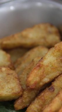 Kızarmış tofu parçaları tabakta taze yeşil biberlerle süslenmiş çıtır çıtır altın-kahverengi tofu küplerini gösteriyor. Tofu iştah açıcı görünüyor, onu ideal bir vejetaryen aperatifi ya da meze yapıyor.