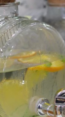 Cam içecek dağıtıcıları. Açık havada açık havada açık büfede açık büfede siyah rafta limonata ve portakal standı bulunan büyük kavanozlar dolusu soğuk limonata. İçkili masalar, el işi hediye kutuları.