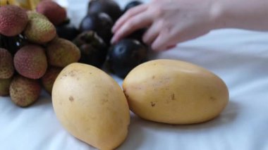 Lychee mango ve mangosten kadın eli yatakta mangosteen topluyor. Yüksek kalite 4k görüntü