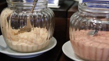 Pürüzsüz kamera hareketi, seçici odaklanma, yuvarlak ahşap tepside beyaz kaselerdeki sosların yakın çekimi. Yüksek kalite 4k görüntü