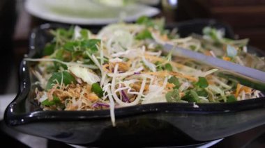 Bir lokantada taze salata, sebze ve tabakla dolu büfeden yemek seçen bir adama yaklaş. Kahvaltıda yemek tercihleri. Yüksek kalite 4k görüntü