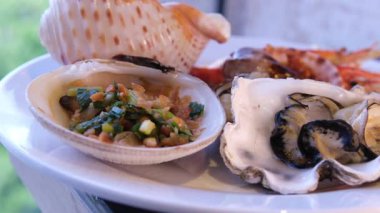 Çeşit çeşit aperatifler, deniz ürünleri ve şenlikli bir yemek için hamur işleriyle dolu bir masa.
