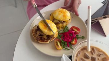 Yeşil tabakta kızarmış yumurta ve ekmek yemek. Yakın plan. Bakış açısı. Renkli arka plan. Tostlu geleneksel kahvaltı. Güneşli bir gün. Yumurtalı Benedict sandviçi.