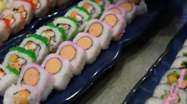 Salatalık dilimleri ve ton balıklı saşimi ile renklendirilmiş suşi ruloları. Yüksek kalite 4k görüntü