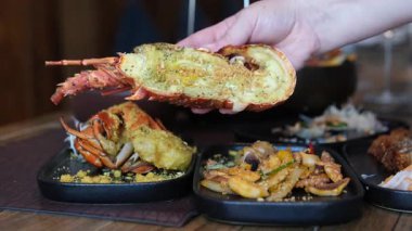 Sebzeli ızgara ıstakoz, canlı tabaklar, deniz ürünleri yeme deneyimi. Yarım bir ıstakozu elimde tutuyorum.