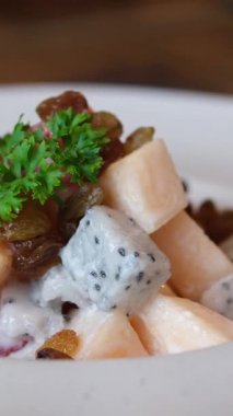 Arka planda dönen renkli meyve salatası. Taze ve lezzetli salatayı portakalla kapat. Yüksek kalite 4k görüntü