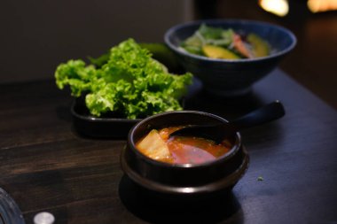 Beyaz arka planda izole edilmiş siyah kasede bir kase domates çorbası. Yüksek kalite fotoğraf