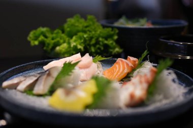 Narin taze somon balığı dilimleri zarif bir tabakta ustalıkla düzenlenir, otlar ve yenilebilir çiçeklerle süslenir, güzel yemekler somutlaştırılır. Yüksek kalite fotoğraf