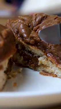 Bıçak çikolata dolu bir çöreği siyah şekerleme ve mor tozla keser. Yüksek kalite 4k görüntü