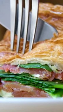 Modern Cafe 'de Jamon jambonlu bir parça kruvasan kes. Cafe' de Sağlıklı Kahvaltı 'nın Üst Manzarası' nda. İngiliz kahvaltısı: kızarmış yumurta, sandviç üzerine pastırmalı tost. Yüksek kalite 4k görüntü