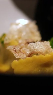 Kadın, taze fesleğeni beyaz tabakta servis edilen makarna kasesine nazikçe yerleştiriyor. Canlı yeşil yapraklar bu güzel basit ve lezzetli yemeğe tazelik katıyor. Yüksek kalite