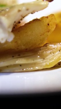 Masadaki kil tabakta kırmızı biberli, patatesli ve Çin lahana salatalı lezzetli alabalık. Kapatın, mutfakta dönüyor. Balık limonlu patates