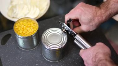 Konserve açacağıyla bir kutu mısır gevreği açmak. Konserve mısırlı metal teneke kutu. Yüksek kalite 4k görüntü