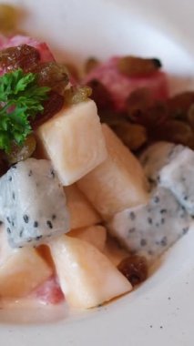 Meyve salatası, kavun, karpuz, beyaz, değerli meyve ve yoğurtla kaplı kuru üzüm. beyaz kalın tabak