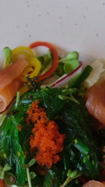 Lezzetli bir somon salatasını karides yumurtasının üstüne koyduğumuz bir video. Bu pek çok insanın sevdiği bir yemek, çünkü baharatı sağlıklı malzemelerden geliyor. Yüksek kalite 4k görüntü