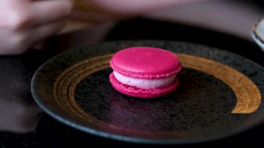 Lezzetli bir kızın ellerinde tatlı ile lezzetli bir makarna. Lezzetli bir kafe pembe ahududu şam fıstığı. Yüksek kalite 4k görüntü