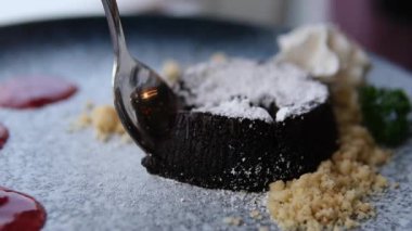 Kaşıktan damlayan çikolatayla kaplı bir kaşıkta çilek. Kaşık gümüş ve çikolata kahverengi. çikolatalı kaşık