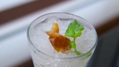 Limon, nane ve suda yüzen zencefil. Taze sarı limonlar beyaz arka planda köpüklerle suya düşüyorlar. Citrus meyveleri kabarcıklarla suya düşüyor. Yavaş çekim yakın çekim. Yüksek kalite 4k